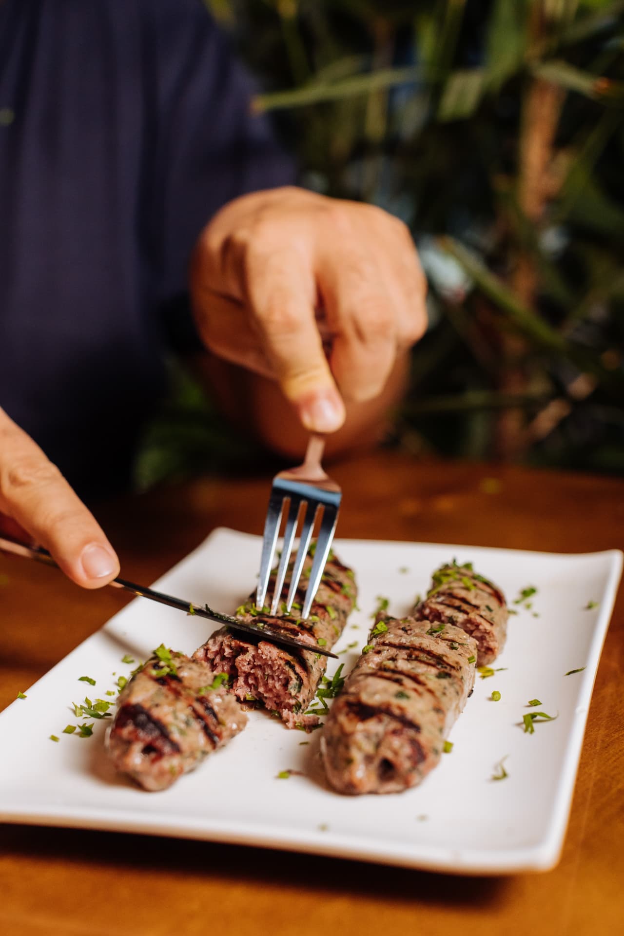 Kafta na brasa sendo cortada à mesa