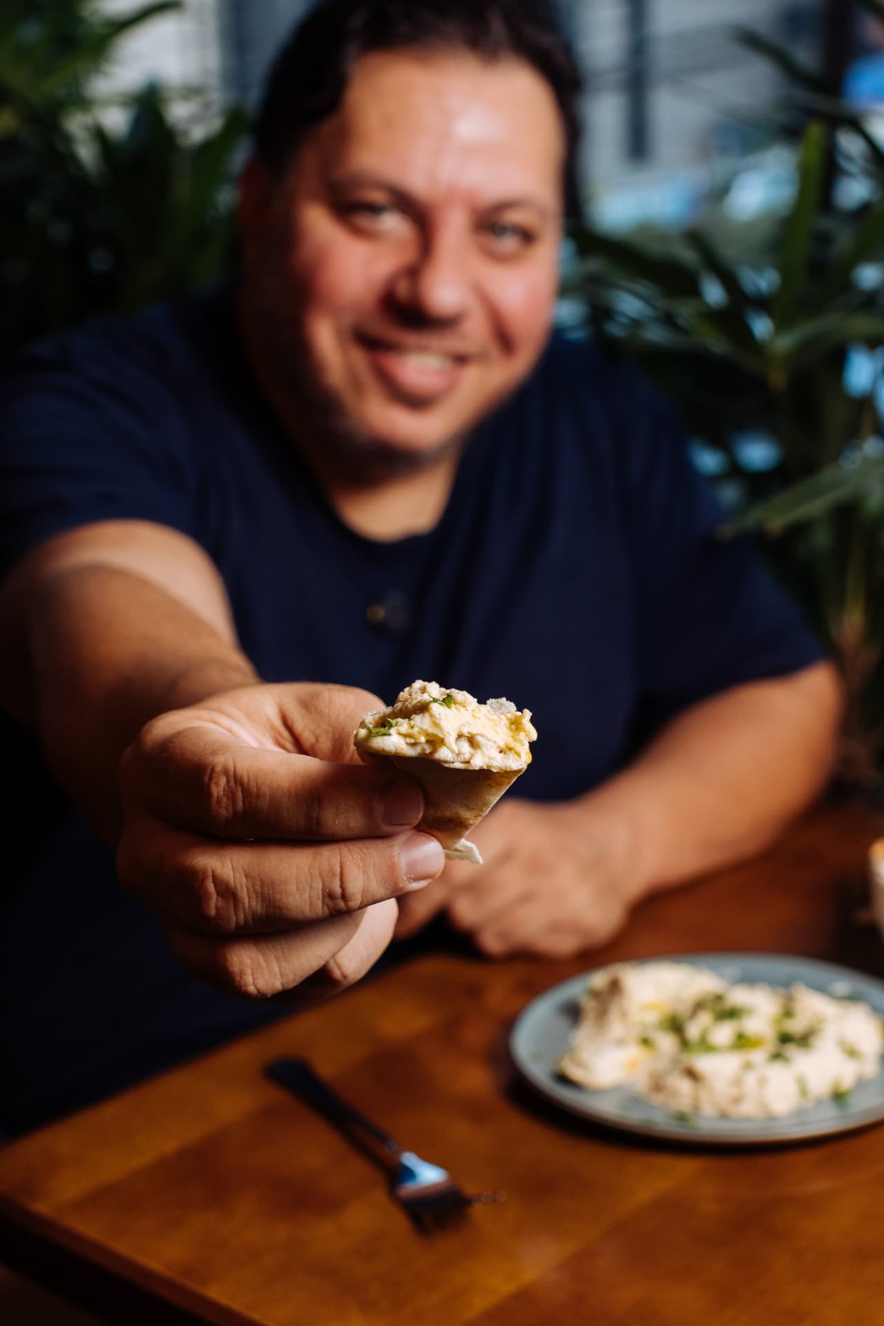 Don Symon oferecendo pão com homus